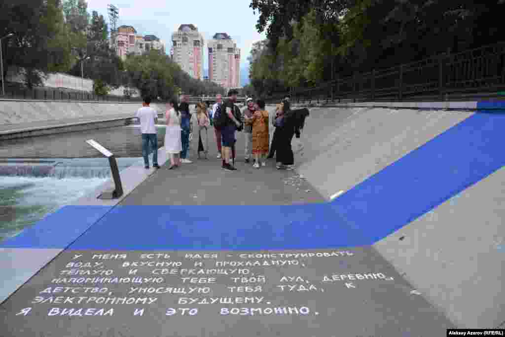 Аида Исаханкызы (Казахстан) создала инсталляцию под названием UNBULTWATERS. Это синяя линия, пересекающая набережную слева и справа от реки, и стихи перед ней. Этой работой Аида хочет привлечь внимание к этому месту, которое можно было бы обустроить для приятного и комфортного отдыха.