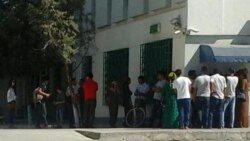 People wait to withdraw cash from an ATM machine in Ashgabat.