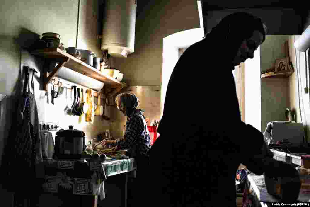 Nadezhda and a guest prepare dinner in the monastery kitchen.