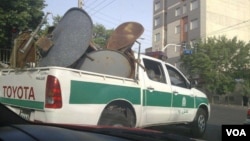 A police car carries dismantled satellite dishes from Iranian homes. (file photo)