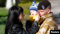 Украинский военнослужащий с членами своей семьи перед отъездом из Крыма. Феодосия, 24 марта 2014 года.