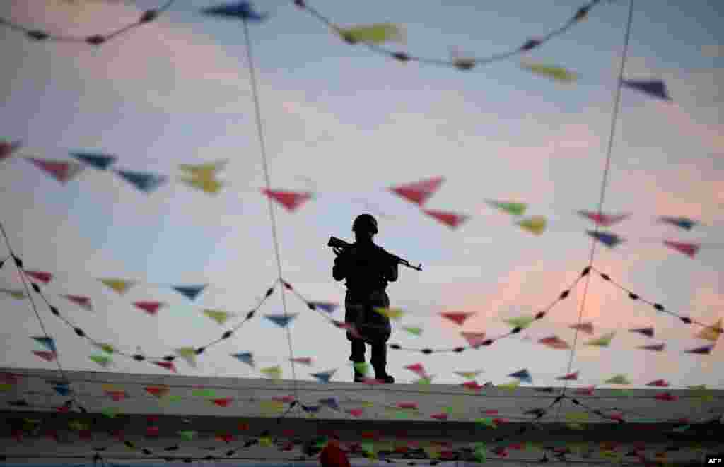 An Afghan policeman stands guard on the roof of the Karte Sakhi Shrine in Kabul as Shi&#39;ite Muslims held a religious ceremony on June 2. (AFP/Farshad Usyan)