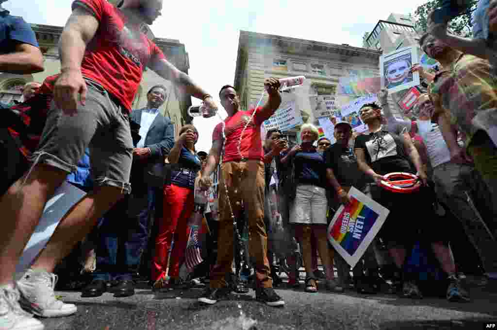 Protesters dump Russian vodka as part of a demonstration against Russian antigay legislation and against Russian President Vladimir Putin's stand on gay rights, in front of the Russian Consulate in New York. (AFP/Emmanuel Dunand)