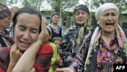 Этнические узбечки, находившиеся в лагере беженцев недалеко от кыргызского города Ош, с плачем просят о помощи. 15 июня 2010 года.