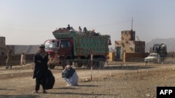 Families cross a military check post as they flee after air strikes on Taliban hideouts in North Waziristan, February 24, 2014.