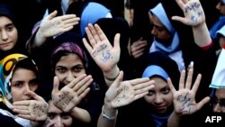 چند دانش‌آموز دختر در مقابل سفارت پیشین آمریکا بر دست‌هایشان شعار مرگ بر آمریکا نوشته‌اند