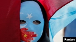 Turkey -- File photo -- An ethnic Uyghur demonstrator wears a mask as she attends a protest against China in front of the Chinese Consulate in Istanbul, Turkey, October 1, 2019