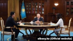 Former Kazakh President Nursultan Nazarbaev (center) made his remarks to interviewers from state TV. 
