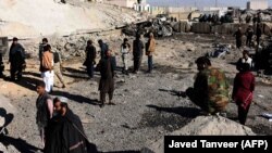 FILE: Afghan security personnel gather at the site of a suicide attack at a police compound in Maiwand district of Kandahar province on December 22.