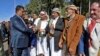 Yemen -- A member of the Huthi delegation (L) returning from peace talks in Sweden shake hands with supporters upon arrival at Sanaa International Airport in the Yemeni capital on December 14, 2019. - The Huthi rebel delegation returned on December 14 to 