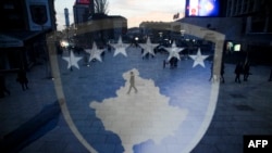 Stema me flamurin e Kosovës e vendosur në vitrinën e një dyqani - Fotografi ilustruese nga arkivi.
