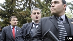 Georgian President Mikheil Saakashvili (left) is surrounded by bodyguards as he visits the Mukhrovani military base after a reported mutiny by soldiers.