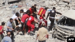 Syrian rescue workers carry a victim on a stretcher following a reported air strike on the rebel-held northwestern city of Idlib on August 17.