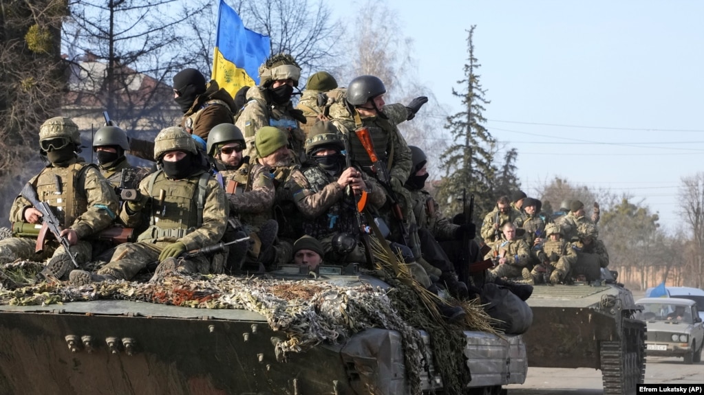Военнослужащие Украины едут на бронетранспортерах в освобожденном от российских военных городе Тростянец Сумской области, 28 марта 2022 года