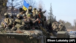 Ukrán katonák páncélozott szállítójárműveken az orosz hadsereg alól felszabadított Trostinec városában, Szumi régióban, 2022. március 28-án.