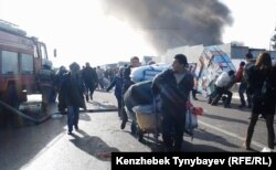 Торговцы вывозят свой товар с горящего рынка. Алматы, 17 ноября 2013 года.