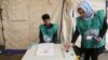 FILE: Afghan employees of the Independent Election Commission (IEC) wait to register residents at a voter registration center for the upcoming parliamentary and district council elections in Kabul.