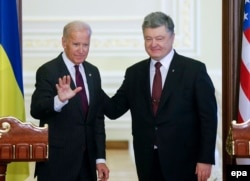 U.S. Vice President Joe Biden (left) waves after a joint press conference with Ukrainian President Petro Poroshenko in Kyiv on January 16.