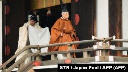 Император Акихито выходит из храма Касикодоро.