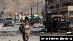 A member of the Afghan security forces keeps watch at the site of a suicide blast in Kabul on November 13.