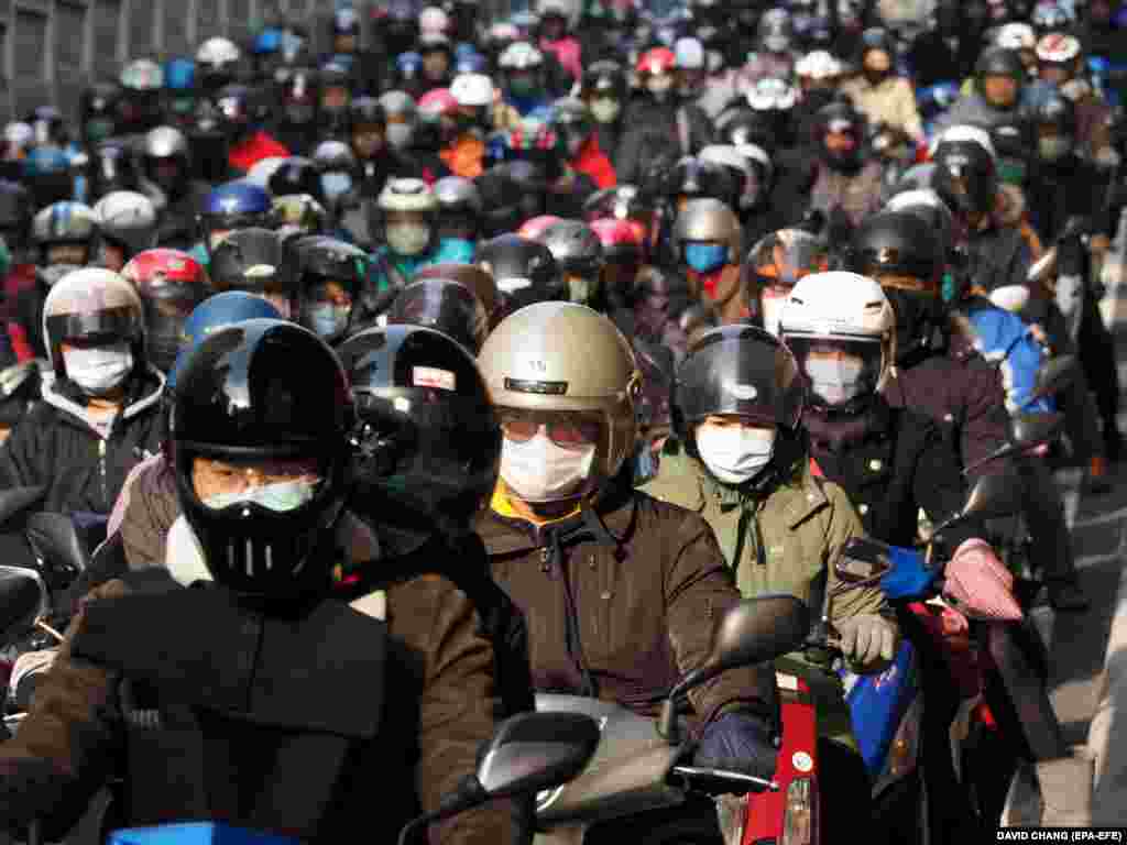 Amid fears of a coronavirus outbreak, Taiwanese commuters wear face masks as they ride motorbikes in Taipei. (epa-EFE/David Chang)