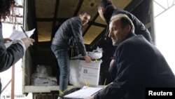 Косово, официјални лица ги пренесуваат кутиите со гласачките ливчиња