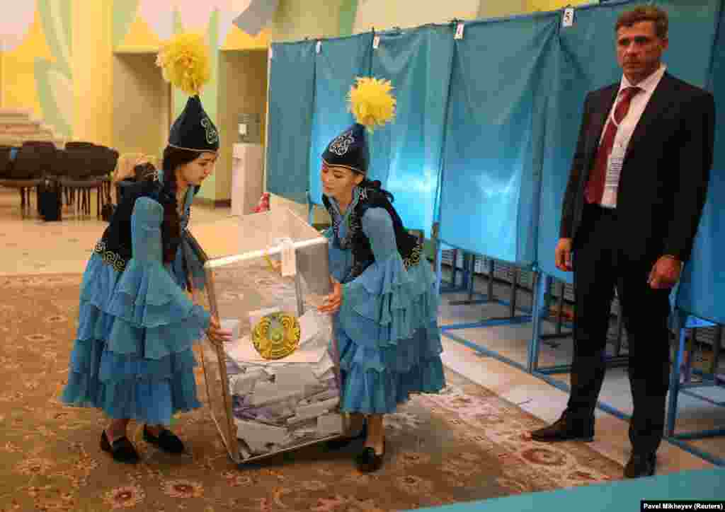 Members of a local Kazakh election committee carry a ballot box before counting votes during the presidential election in Almaty on June 9. (Reuters/Pavel Mikheyev)