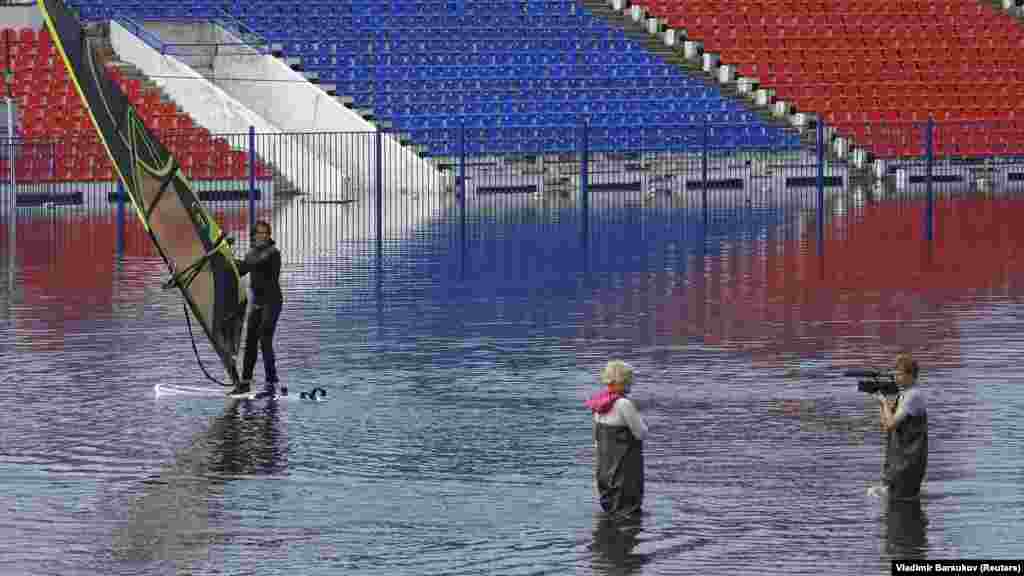 A man windsurfs at flooded Lenin Stadium, the home arena of the local soccer club SKA-Energia, in the Russian Far East city of Khabarovsk. (Reuters/Vladimir Barsukov)