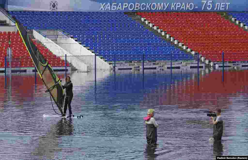 Чалавек займаецца віндсэрфінгам на затопленым стадыёне імя Леніна ў Хабараўску на расейскім Далёкім Усходзе 1 верасня. Паводка ў жніўні і верасьні была найгоршай у Расеі за апошнія 120 гадоў і каштавала краіне амаль 1 мільярд даляраў.