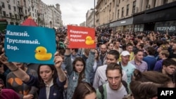 Protesters hold posters reading " Corruption steals the future" and "Miserable cowardly thief" during an anticorruption rally in central Moscow on June 12.