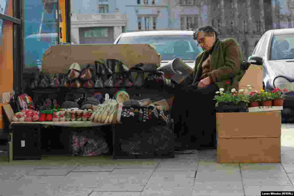 Hedging your bets: A street seller in Tbilisi offers winter clothing alongside spring flowers. Photo by Levan Mikadze.