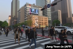 Люди переходят улицу в Сеуле. Иллюстративное фото.