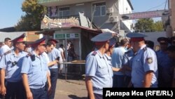 Шымкенттегі Орталық Қырғы базары алдындағы дүргіршектерді бұзып жатқан жерде жүрген полицейлер. 30 шілде 2018 жыл.