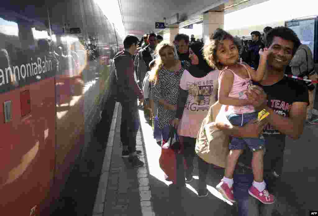Беженцы сходят с поезда, прибывшем из Венгрии, на одном из вокзалов столицы Австрии Вены. 7 сентября.