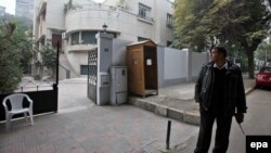 A plainclothes officer stands guard at the entrance of a building hosting the offices of an unspecified nongovernmental group in the Egyptian capital, Cairo, on December 30.