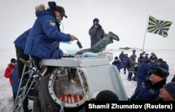 Спасатели извлекают космонавтов из капсулы после аварийной посадки в декабре 2018 года