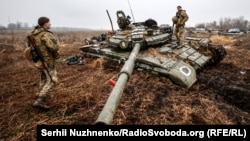 Украинские военные рядом с уничтоженной российской техникой