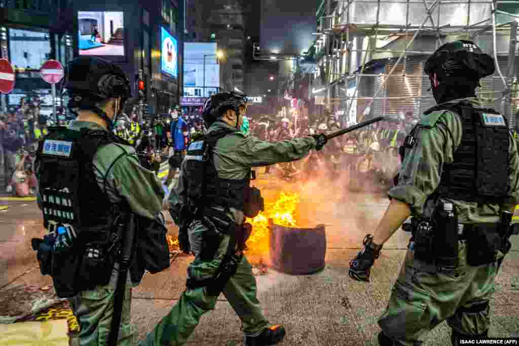 Поліція стоїть на сторожі, щоб утримати протестувальників від блокування доріг у районі Монг Кок у Гонконгу. Поліція Гонконгу застосувала сльозогінний газ й арештувала сотні людей у центральному діловому районі міста, де 27 травня тисячі людей вийшли на протест проти можливого ухвалення законопроєкту, який криміналізує &laquo;неповагу&raquo; до національного гімну Китаю. У поліції повідомили, що затримали понад 300 осіб, переважно за підозрою в участі у незаконному мітингу (Photo by ISAAC LAWRENCE / AFP)
