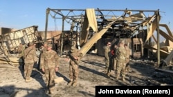 U.S. soldiers inspect the site where an Iranian missile hit at the Ain al-Asad Air Base in Iraq on January 13.