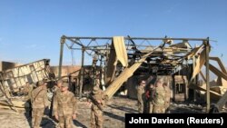 Американские военные проводят осмотр места попадания иранской ракеты на территории авиабазы Аль-Асад в иракской провинции Анбар. 13 января 2020 года.