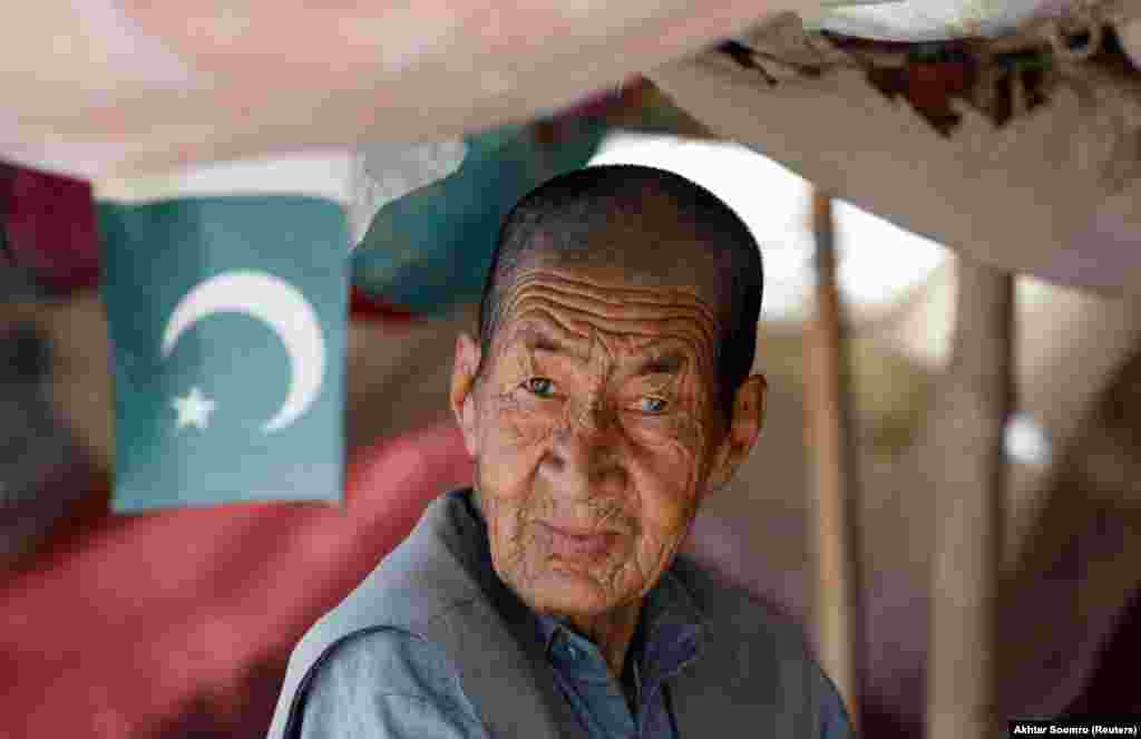 Ibrahim Hazara, 70, poses for a photograph while selling apricots from his push cart at a vegetable and fruit market in Mariabad, Quetta, Pakistan, June 15, 2019.