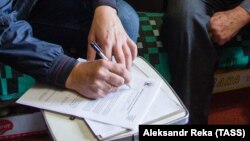 UKRAINE -- A census enumerator notes details from a resident during a population count in the rebel-controlled city of Luhansk, October 1, 2019