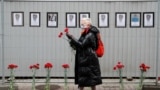 RUSSIA -- A woman wearing a protective mask holds flowers near a makeshift memorial for medics, who reportedly died in Saint Petersburg and Leningrad Region in the times of the coronavirus disease (COVID-19) outbreak, in central St. Petersburg, April 28, 