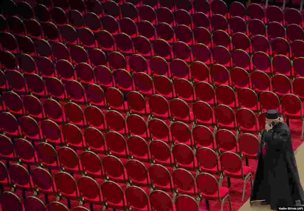 A priest speaks on the phone next to empty seats after the blessing service of the National Cathedral in Bucharest, Romania. (AP/Vadim Ghirda)