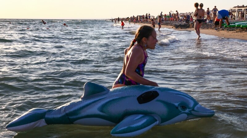 Девочка с надувным дельфином на пляже в селе Поповка | Крымское фото дня