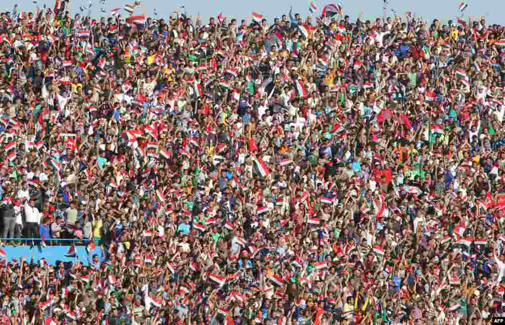Iraqi fans wave their national flag as their team plays a friendly football match against Syria at the Al-Shaab Stadium in Baghdad. FIFA lifted a ban on international football friendlies in Iraqi stadiums, permitting matches in Baghdad for the first time since the 2003 U.S.-led invasion. (AFP/Ahmad al-Rubaye)