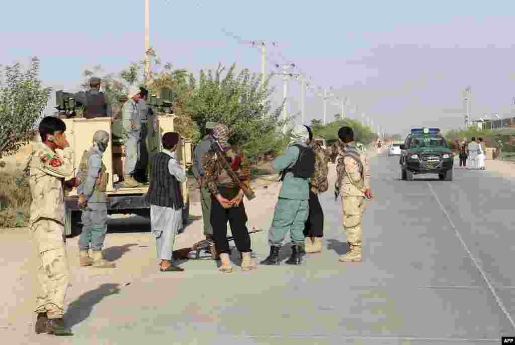 Afghan security forces gather at a roadside a day after Taliban insurgents overran Kunduz.