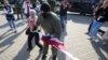 Сотрудник ОМОНа отбирает флаг у пенсионерки Нины Багинской