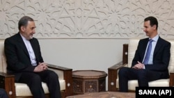 Syrian President Bashar Assad (R) meets with Akbar Velayati, a top adviser to Iran's supreme leader, in Damascus, April 12, 2018