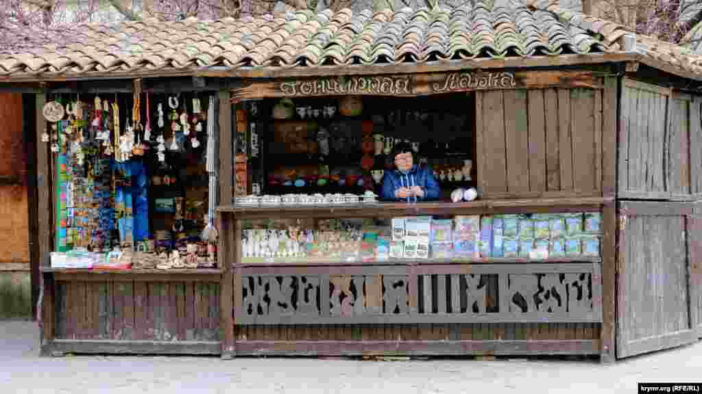Скучающий продавец в сувенирной лавке. В конце марта в городе мало туристов